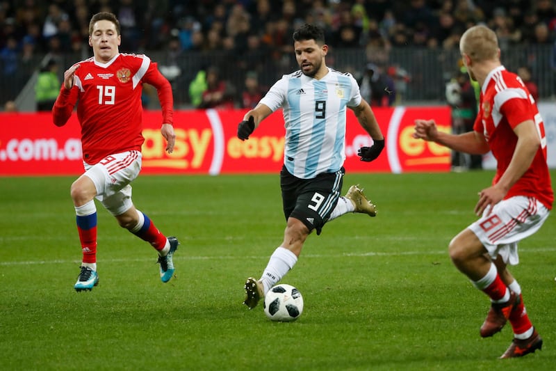 Argentina's Sergio Aguero, center, takes the ball forward watched by Russia's Daler Kuzyaev, left, and Russia's Denis Glushakov during the international friendly soccer match between Russia and Argentina at Luzhniki World Cup 2018 stadium in Moscow, Russia, Saturday, Nov. 11, 2017. (AP Photo/Pavel Golovkin)
