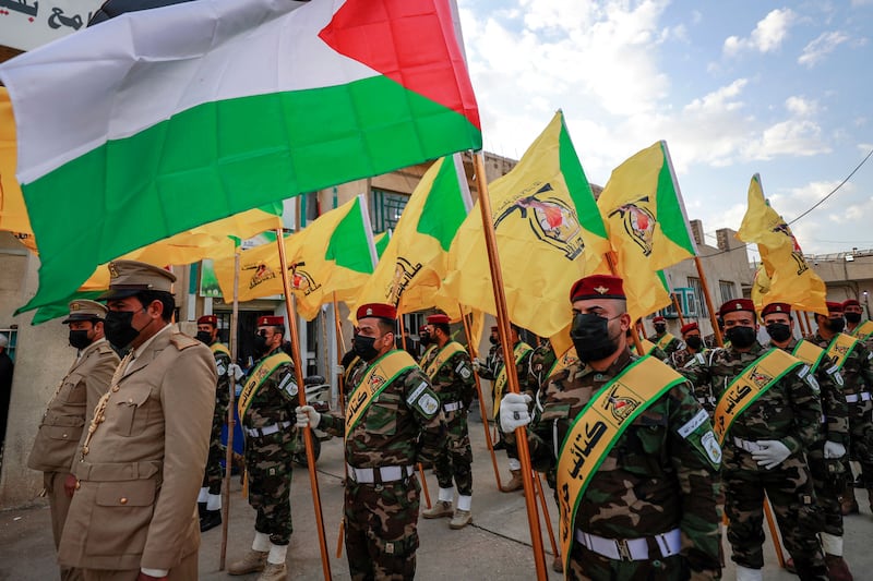 Members of Kataib Hezbollah attend the funeral of one of its fighters, Fadel Al Maksusi, on Tuesday. AFP