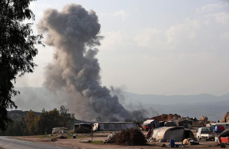 Smoke billows into the sky after reported air strikes on a prison on the western outskirts of the Syrian city of Idlib, inside the jihadist-held bastion of the same name, on March 13, 2019.  / AFP / OMAR HAJ KADOUR
