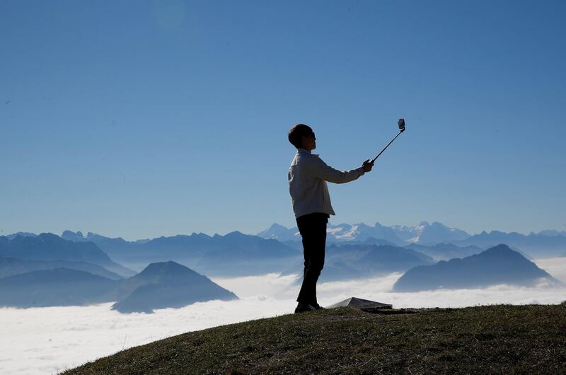 A man takes a selfie on sunny autumn day near the peak of Mount Rigi, Switzerland. Reuters