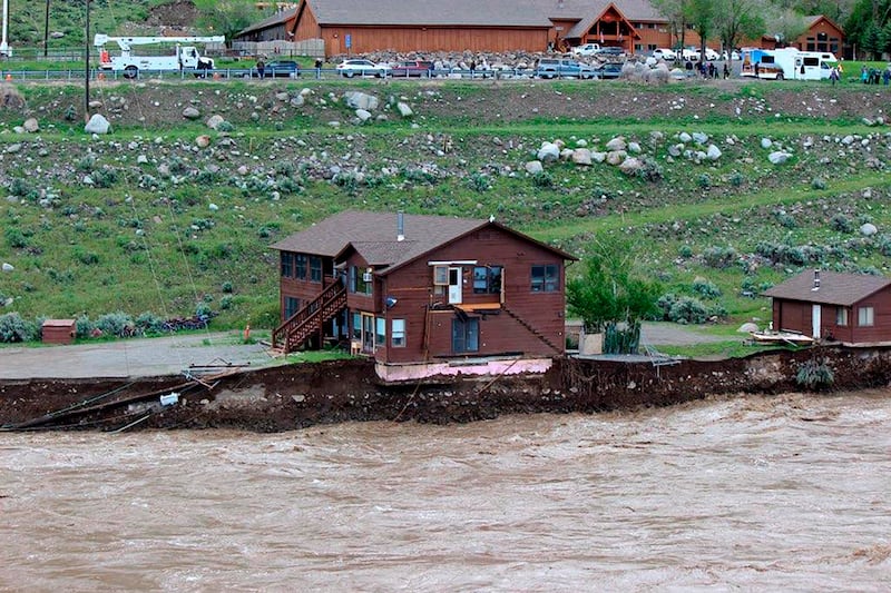 The flooding Yellowstone River undercuts the river bank, threatening a house and a garage in Gardiner, Montana. Sam Glotzbach / AP