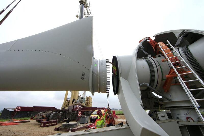 Employees work on a rotor blade assembling to the hub of an E-70 wind turbine. Benoit Tessier / Reuters