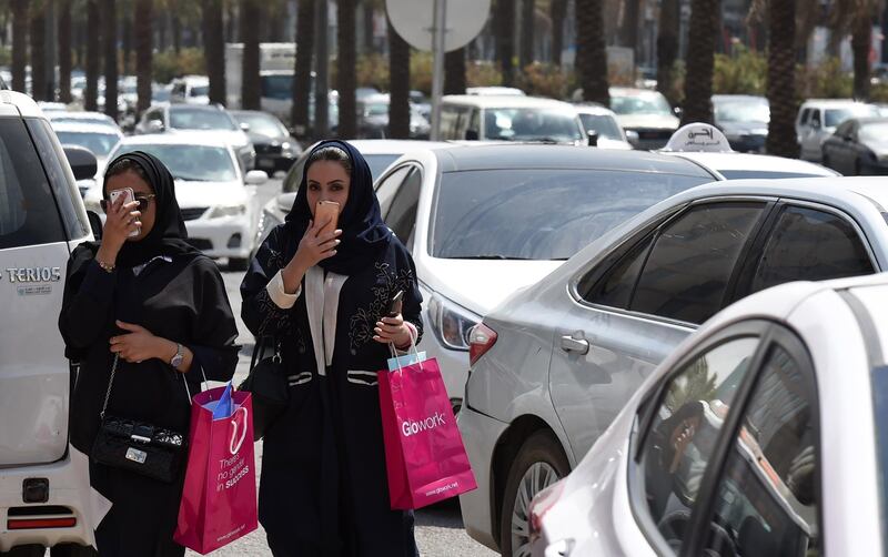 Saudi women walk amidst vehicles at a street in the Saudi capital Riyadh, on September 28, 2017. 
Saudi Arabia will allow women to drive from June 2018, state media said on September 26, 2017 in a historic decision that makes the Gulf kingdom the last country in the world to permit women behind the wheel. The shock announcement comes after a years-long resistance from women's rights activists, some of whom were jailed for defying the ban on female driving. / AFP PHOTO / FAYEZ NURELDINE