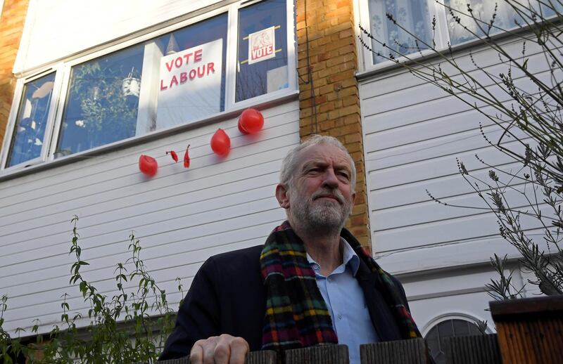 Britain's Labour Party leader Jeremy Corbyn is seen outside his house, with political election campaign messages seen on the adjoining property, in London, Britain, December 14, 2019. REUTERS/Toby Melville