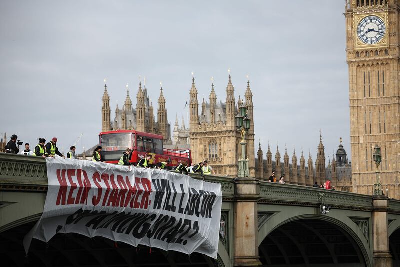 A banner reading 'Keir Starmer: Will Labour Stop Arming Israel?' is hung over the side of Westminster Bridge, in front of the Palace of Westminster, home to the houses of Parliament, in London. AFP