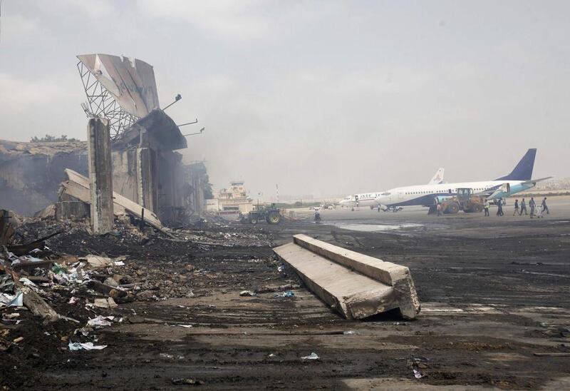 Planes are seen near a section of a damaged building, left, at the airport. Athar Hussain/Reuters
