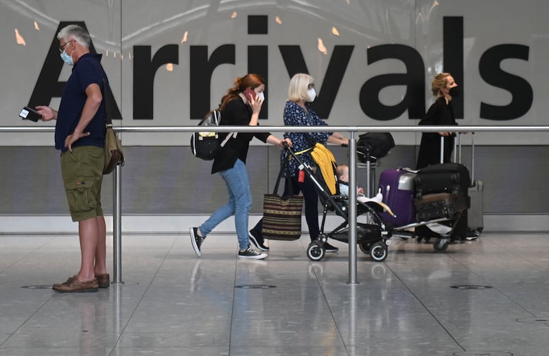 Travellers make their way through Terminal 5 at Heathrow Airport after returning to the UK.