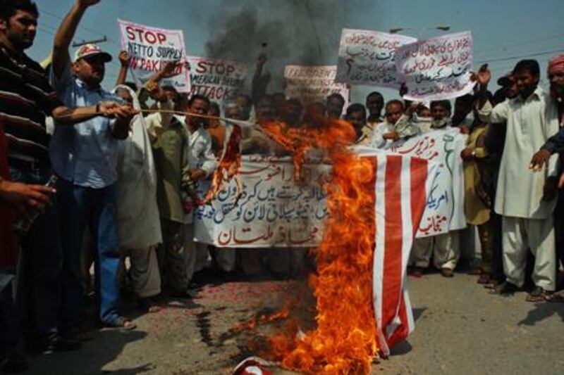 Pakistanis torch a US flag in an October 10 protest in Multan against US drone attacks in the Waziristan area.