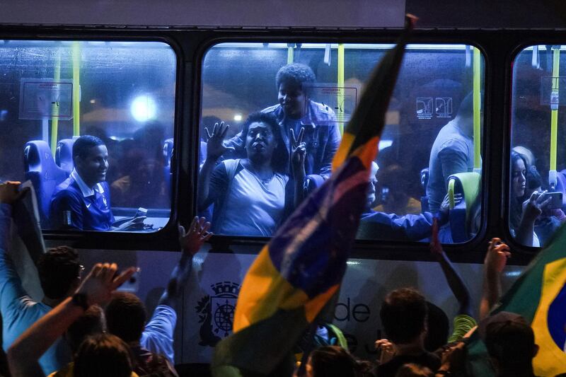 Supporters of Jair Bolsonaro celebrate in a bus in front of his house in Rio de Janeiro. AP Photo