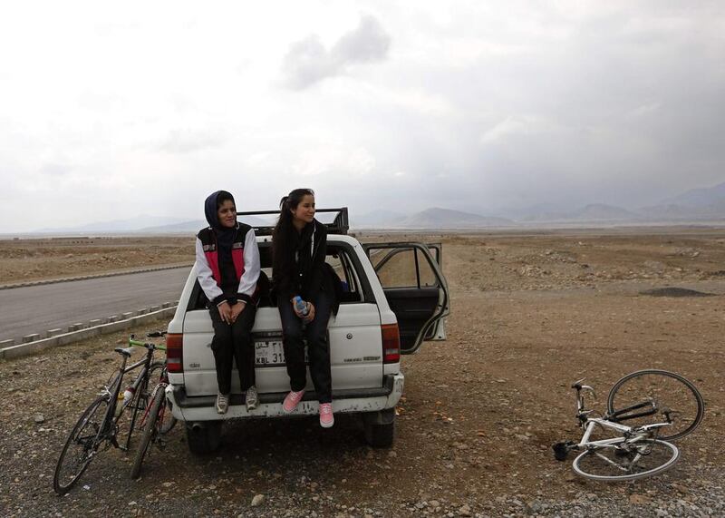 Members of Afghanistan’s Women’s National Cycling Team sit on the back of a car after a training exercise. Mohammad Ismail / Reuters