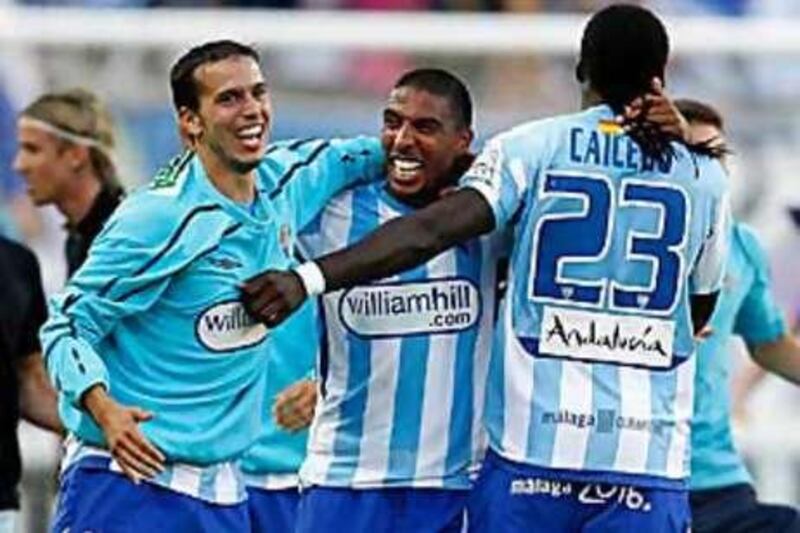 Malaga players celebrate avoiding relegation last season.