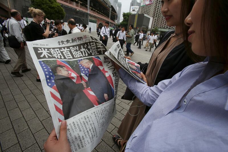 People look at an extra edition of the newspaper Yomiuri reporting about the summit, in Tokyo. Koji Sasahara / AP Photo