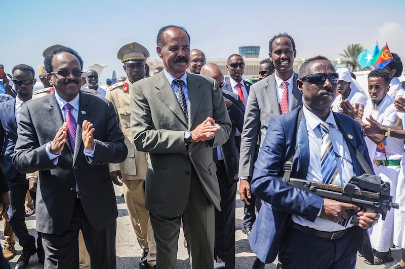 Somalia's President Mohamed Abdullahi Farmajo (L) and Eritrea's President Isaias Afwerki (2nd L) applaud after reviewing the honour guard upon Afwerki's arrival at Aden Abdulle international airport in Mogadishu, on December 13, 2018.  / AFP / Mohamed ABDIWAHAB
