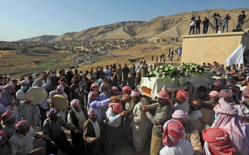 Iraqi Yazidi men surround the casket of Baba Sheikh Khurto Hajji Ismail, supreme spiritual leader of the Yazidi religious minority, during his burial in the town of Buza on October 2. AFP