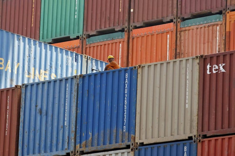 A worker sits on a ship carrying containers at Mundra Port. Amit Dave / Reuters