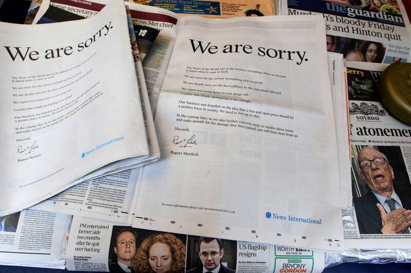 Newspapers are opened to show the advertisement apology for News International and photographed at a news vendor in central London, Saturday, July 16, 2011.  News Corporation chairman Rupert Murdoch signed the company advert entitled "We are sorry",  which appears in British national newspapers Saturday.  The News International publication News of the World is accused of hacking into the mobile phones of various crime victims, celebrities and politicians. (AP Photo/Sang Tan) *** Local Caption ***  Britain Phone Hacking.JPEG-080df.jpg