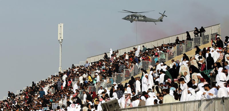 Crowds watch as a helicopter swoops in for a live action hostage rescue mission