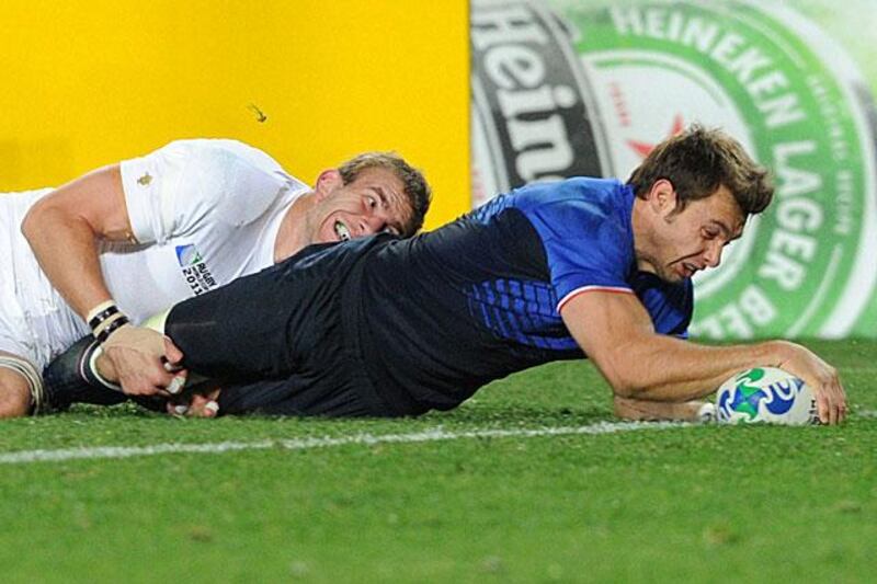 Tom Croft's desperate tackle is in vain as Vincent Clerc, the France winger, scores a try in the first-half which left England chasing the game.

Gabriel Bouys / AFP