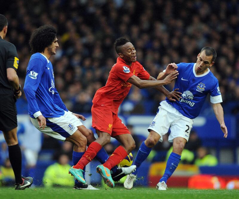 epa03450447 Liverpool's Raheem Sterling (C) in action against Everton's Leon Osman (R) and Marouane Fellaini (L) during the English Premier League soccer match between Everton and Liverpool at Goodison Park, Liverpool, Britain, 28 October 2012.  EPA/PETER POWELL DataCo terms and conditions apply.  http//www.epa.eu/downloads/DataCo-TCs.pdf *** Local Caption ***  03450447.jpg