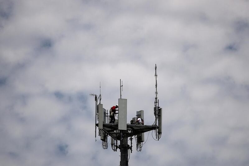 Workers install 5G telecommunications equipment on a T-Mobile US Inc tower in Seabrook, Texas, U.S. May 6, 2020. REUTERS/Adrees Latif