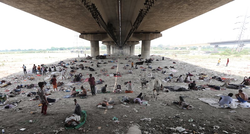 People shelter under a bridge from scorching heat in New Delhi. EPA