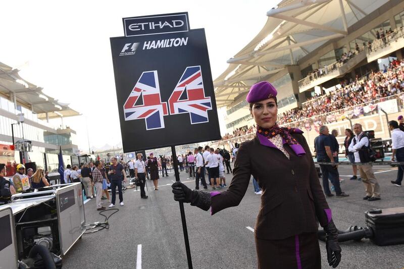 An Etihad Airways' cabin crew member holds pole-sitter Lewis Hamilton's grid board. Andrej Isakovic / AFP Photo