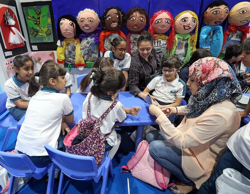 Amal Al Ahmad teaches pupils of from Ajyal International School how to make puppets on the final day of the Abu Dhabi International Book Fair at Adnec on Tuesday, where the major push to encourage Emiratis to read was launched.  Satish Kumar / The National