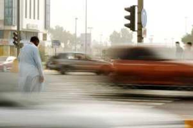 12/03/09 - Abu Dhabi, UAE -  A man looks at traffic as he crosses Airport Rd. in Abu Dhabi.  Yesterday, a French tourist was run down and killed yesterday on a pedestrian crossing in the capital, just 90 minutes after he had disembarked from his cruise ship. (Andrew Henderson/The National) *** Local Caption ***  ah_090312_Crosswalks_0122.jpg