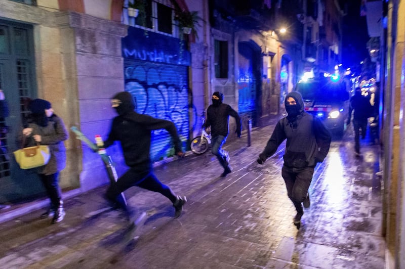 Masked protesters run away from a van of the Catalan regional police, or Mossos d'Esquadra, during a protest of the squatting movement of Barcelona in Spain. EPA