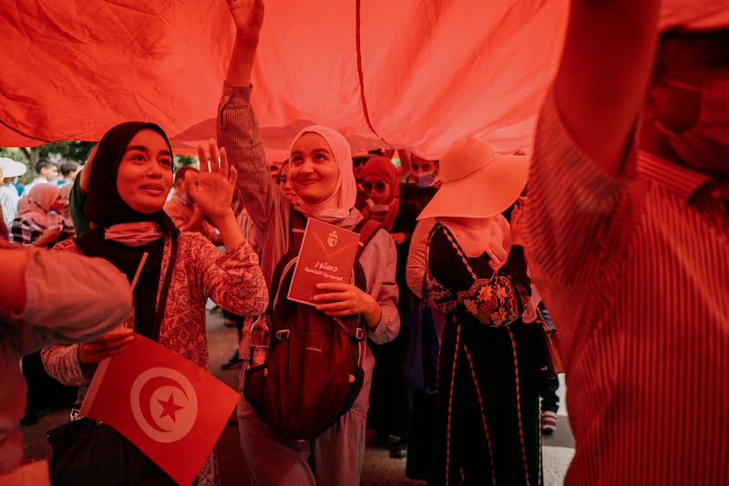 Protesters gather under the giant Tunisian flag.