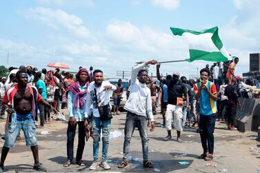 A protester waves a Nigerian flag during a protest against police brutality on the Lagos-Ibadan expressway at Magboro, Ogun State in October. AFP