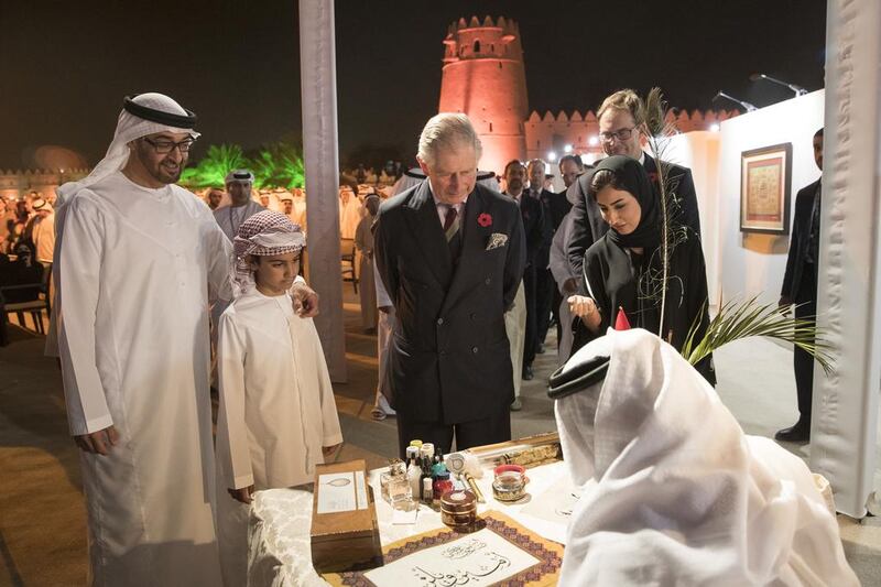 Sheikh Mohammed bin Zayed, Crown Prince of Abu Dhabi and Deputy Supreme Commander of the Armed Forces, watches as calligrapher Mohamed Mandi writes Prince Charles’s name at the launch of the UK-UAE Year of Cultural Collaboration at Al Jahili Fort in Al Ain. With Sheikh Mohammed is Sheikh Zayed bin Abdullah.  Ryan Carter / Crown Prince’s Court – Abu Dhabi