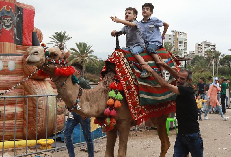Syrian children ride a camel as they play in a park in the Lebanese capital Beirut during Eid Al Adha. AFP