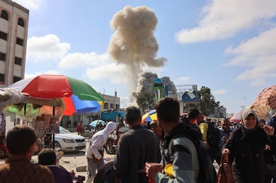 Palestinians look at smoke billowing during Israeli bombardment on the Firas market area in Gaza city. AFP