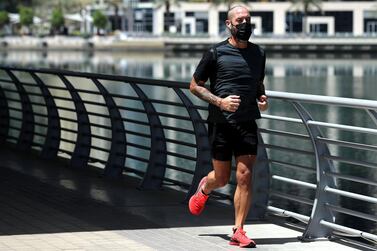 A man runs around Dubai Marina on the first morning of Ramadan. Chris Whiteoak / The National