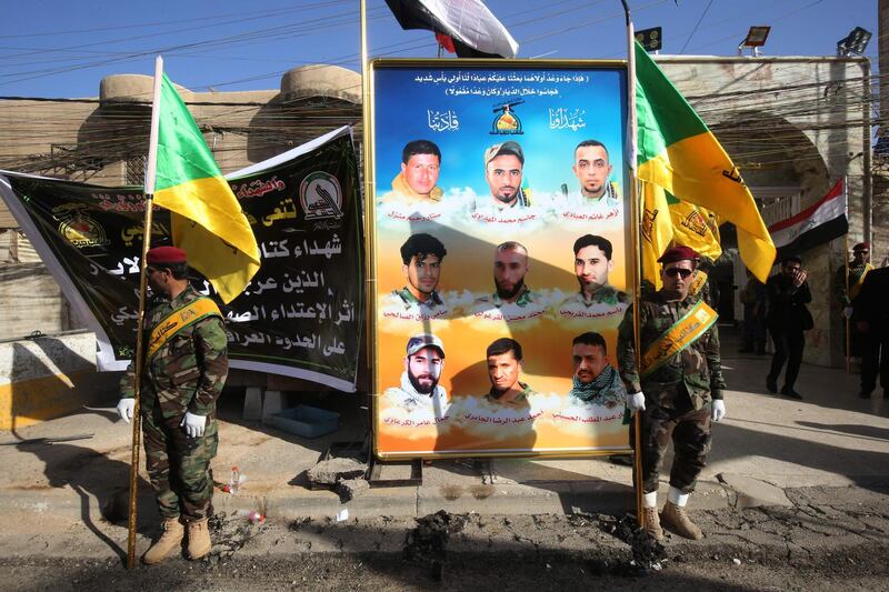 Members of the Iraqi Hezbollah Brigades, part of the Hashed al-Shaabi paramilitary units, carry flags in front of portraits of fellow members who were killed in air raids 4 days earlier, during a memorial ceremony in Baghdad on June 21, 2018.  The air strike that hit targets in eastern Syria near the frontier with Iraq where forces on the ground are battling Islamic State Group (IS) remnants, reportedly left more than 50 people dead, state media and a Britain-based monitor said.
Both Damascus and the Iran backed-Hashed have blamed the US-led coalition for the raids, but the coalition and the Pentagon denied any involvement.


 / AFP / AHMAD AL-RUBAYE
