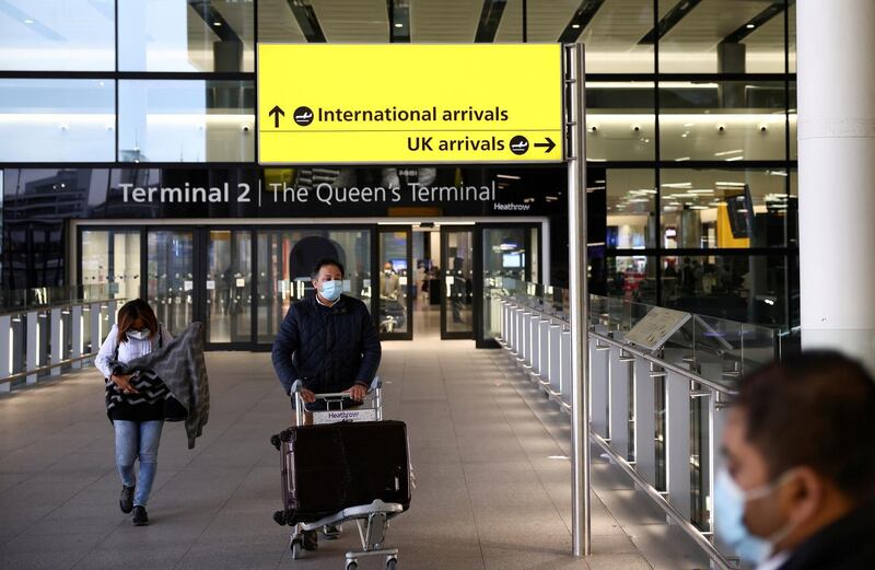 FILE PHOTO: Travellers walk through Terminal 2 at Heathrow Airport, amid the coronavirus disease (COVID-19) outbreak in London, Britain February 14, 2021. REUTERS/Henry Nicholls//File Photo