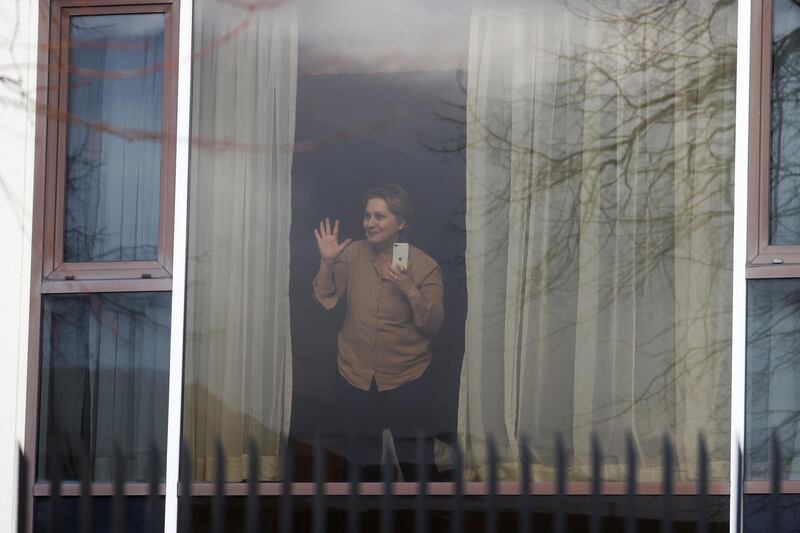 Zari Tadayon gestures from a window of the Radisson Blu Hotel at Heathrow Airport, as Britain introduces hotel quarantine programme for arrivals from a "red list" of 30 countries, in London, Britain, February 15, 2021. REUTERS/Hannah McKay