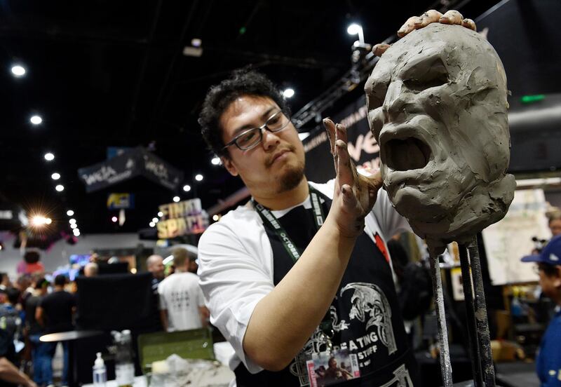Sculptor Sam Gao works on a clay model during Preview Night. AP Photo