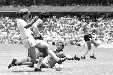 FILE - In this June 22, 1986 file photo, Argentina's Diego Maradona, second left, is about to score his second goal against England, during a World Cup quarterfinal soccer match against England, in Mexico City.  England's Terry Butcher, left, tries to tackle Maradona, while England's goalkeeper Peter Shilton is on the ground.  Gio Reyna, the son of former U. S.  captain Claudio Reyna and women's national team midfielder Danielle Egan, was compared with Maradona in the '86 World Cup by U. S.  coach Gregg Berhalter after a USA vs Mexico qualifying match in Mexico City on Thursday, March 24, 2022. (AP Photo / File)