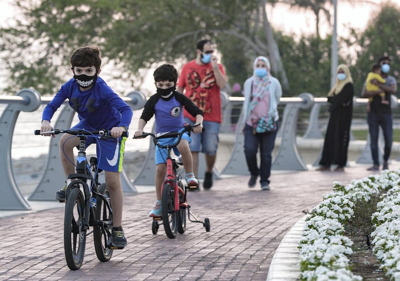 Abu Dhabi, United Arab Emirates, May 28, 2020.  Two boys on their bikes speed along the Corniche-Marina Mall pathway as the sun sets during the Covid-19 pandemic.  Victor Besa  / The National
Section:  Standalone / Stock