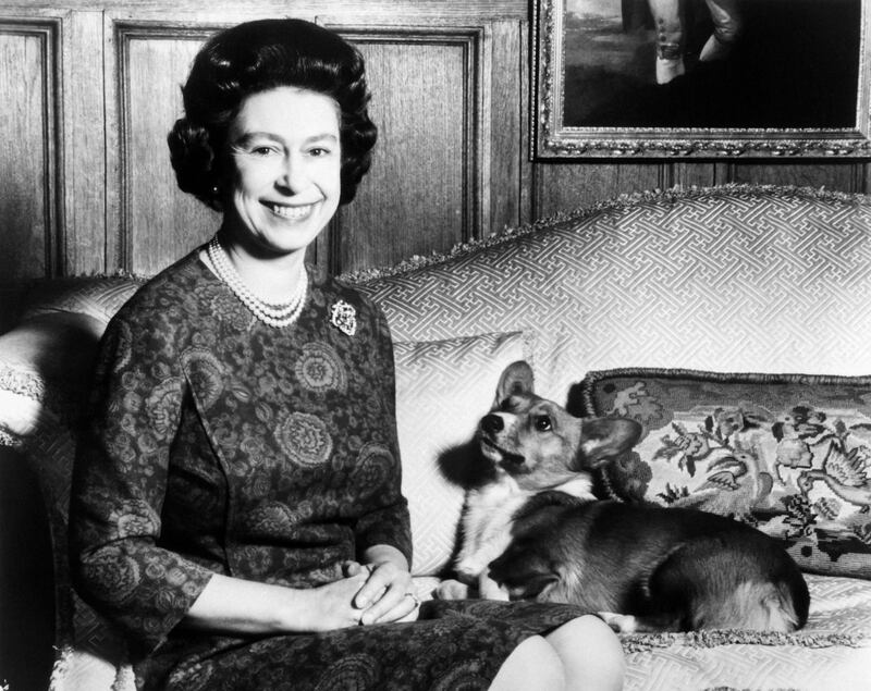 The queen and one of her corgis. AFP