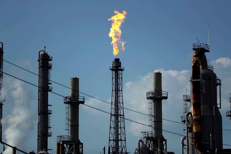 FILE - In this Thursday, Aug. 31, 2017, file photo, a flame burns at the Shell Deer Park oil refinery in Deer Park, Texas. The price of crude oil barely moved in 2017, and energy companies faded after a big gain the year before. (AP Photo/Gregory Bull, File)