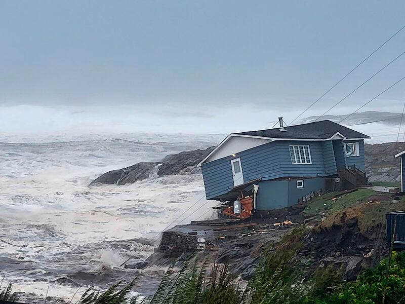 A home teeters on the brink amid high winds caused by Fiona in Port aux Basques, Newfoundland and Labrador. AP