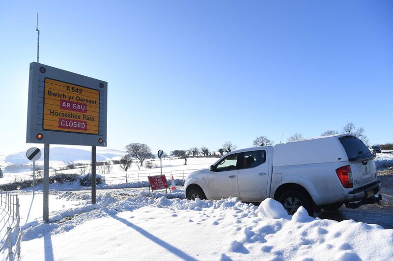 A sign alerts drivers to road closures near Wrexham, north Wales as heavy snowfall blankets the area on December 11, 2017.
The heaviest snowfall to hit Britain in four years caused widespread yesterday with roads becoming hazardous and flights grounded following runway closures. / AFP PHOTO / Paul ELLIS