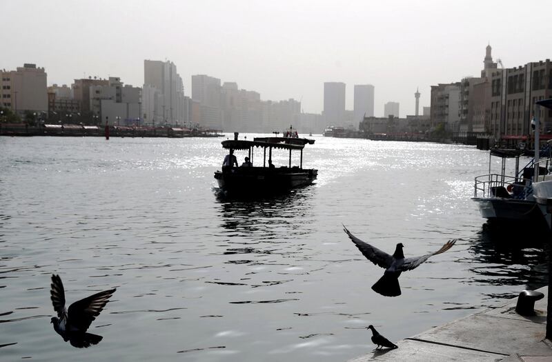 Dubai, United Arab Emirates - July 28, 2019: Standalone. Pigeons fly over Dubai Creek on a hazy day. Sunday the 28th of July 2019. Bur Dubai, Dubai. Chris Whiteoak / The National