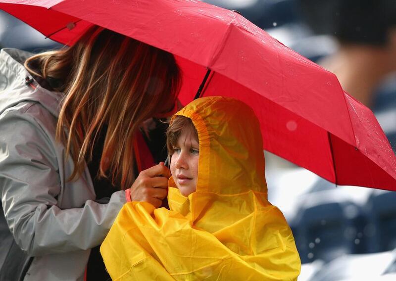 Tennis fans shelter under umbrellas as rain delays play on day three of the WTA Dubai Duty Free Tennis Championship. Francois Nel / Getty Images