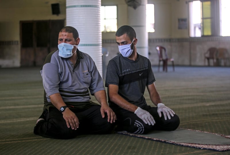 Palestinian men pray at an almost-empty mosque in Rafah in the Gaza Strip, before prayers at places of worship were suspended. AFP