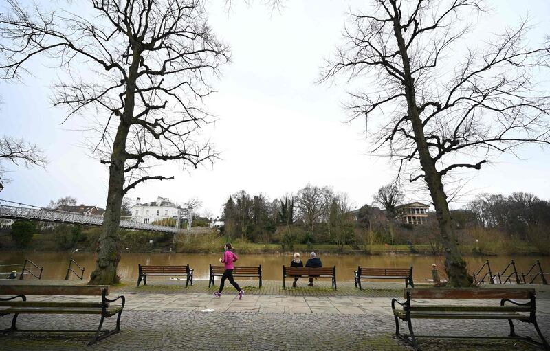 People exercise by on the banks of the River Dee in Chester. AFP