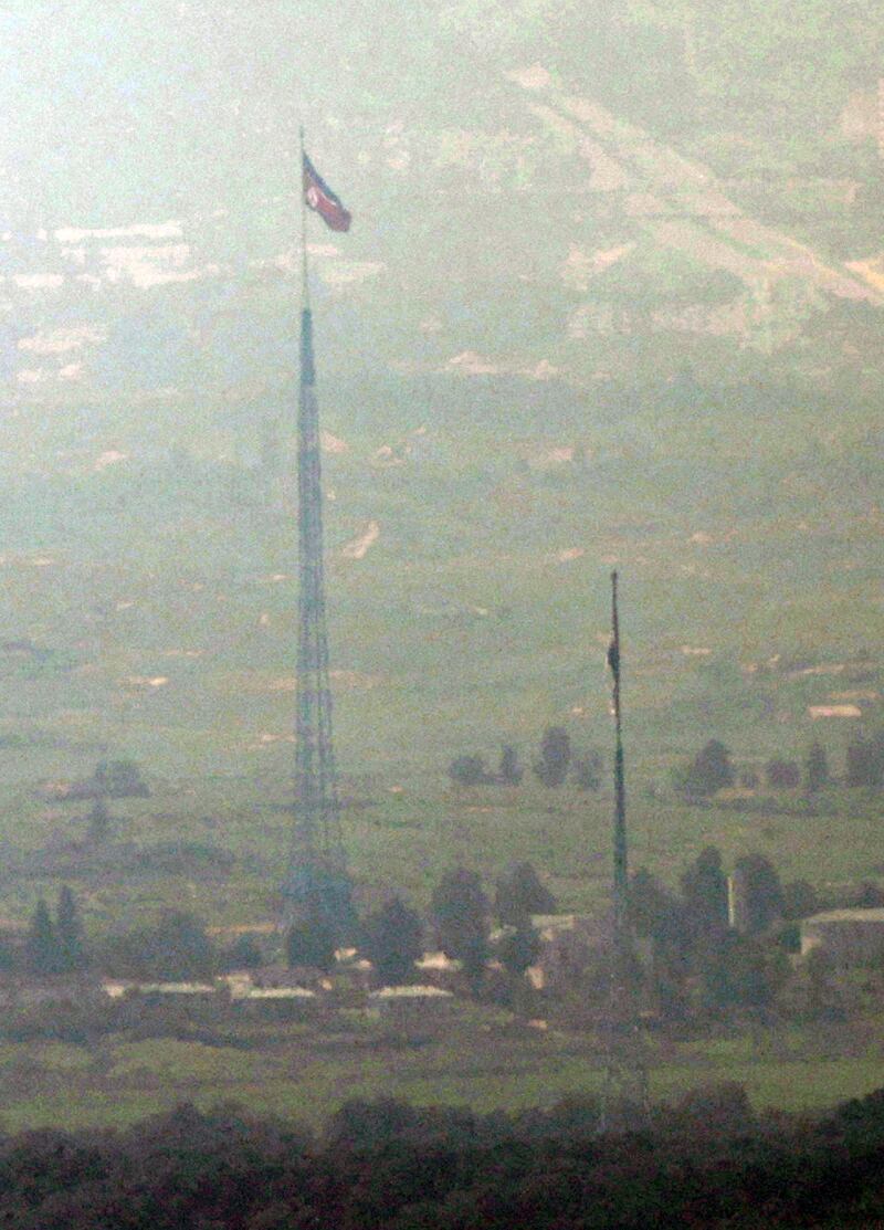 The flags of South and North Korea fly in the South's Daeseong Village, bottom, and the North's Kijong Village, top, in this photo taken from an observatory in the South Korean border city of Paju on July 27, 2021.  The two Koreas reopened direct cross-border communication lines that Pyongyang severed last year.